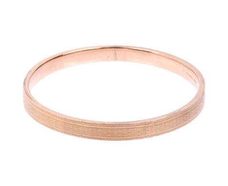 An early 20th century 9ct rose gold plain slave bangle, maker S&amp;P, Birmingham 1929, allover engine turned decoration, ban