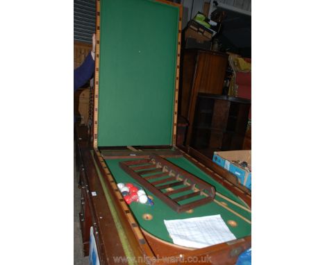 A full size table top fold-over Mahogany Bagatelle Board with balls and cues, the Mahogany panelled fold-over top opening to 