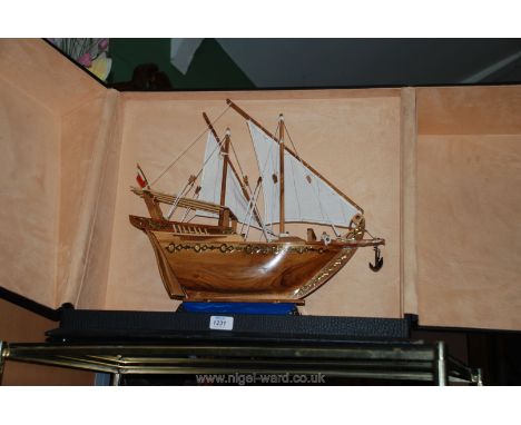 A cased model of a ship from Bahrain on a lapiz coloured base.