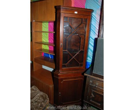 A reproduction Mahogany finished floor standing, two door Corner Cabinet, having castellated moulded top, over the upper 13 p