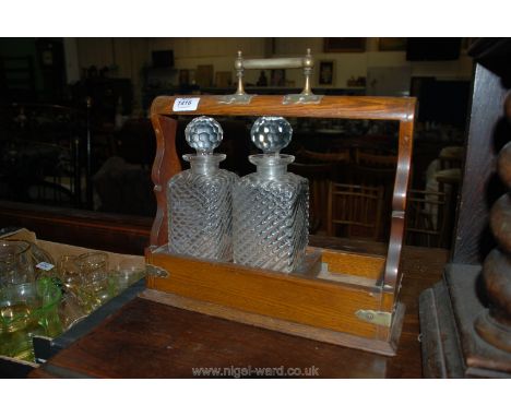 A Tantalus with two decanters, one missing