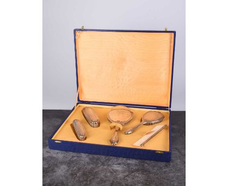 A cased white metal mounted dressing table set, comprising; a hand mirror, three brushes and a comb, indistinctly stamped '80