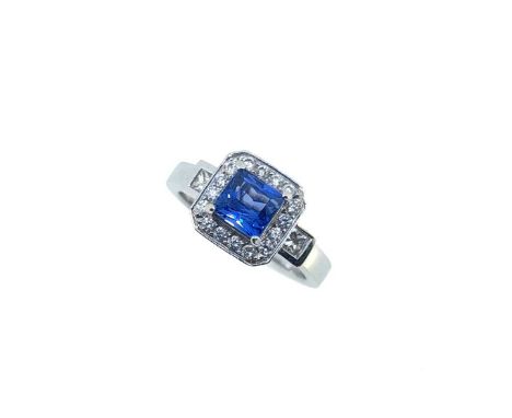 claw set square faceted sapphire, approximately 5.5 x 5.2mm, surrounded by sixteen grain set round brilliant cut diamonds, he