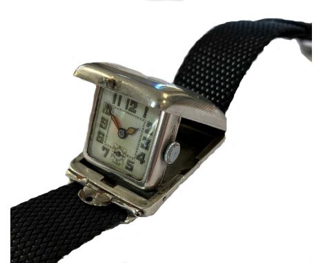 circa 1934, the rectangular convex outer case, 25mm wide, upper with geometric engine turned decoration, sprung hinged at 12 