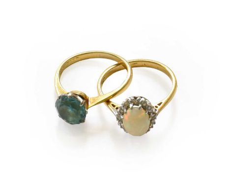 An opal and diamond cluster ring, stamped '18CT' and 'PLAT', finger size L; and a blue topaz ring, stamped '18CT PLAT', finge