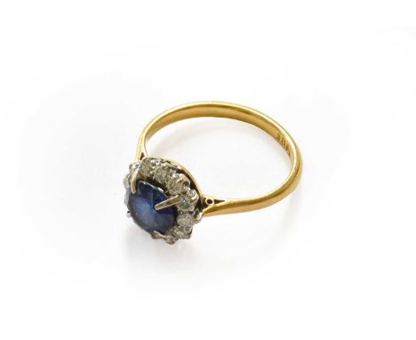 A sapphire and diamond cluster ring, stamped '18CT', finger size LThe ring is in fair condition with surface abrasion to the 