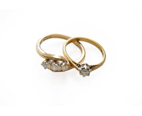 A 9 carat gold diamond three stone twist ring, finger size M; and an 18 carat gold diamond solitaire ring, finger size JThree