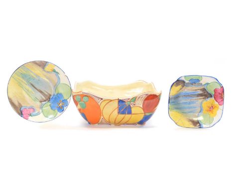 Three pieces of Clarice Cliff, all damaged to include a Bizarre 'Pansies' square dish with A.J. Wilkinson stamp to base diame