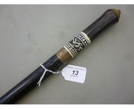 An antique swordstick, the tapered ebonised shaft with a brass tip, the turned handle having a carved bone ferrule and a lion
