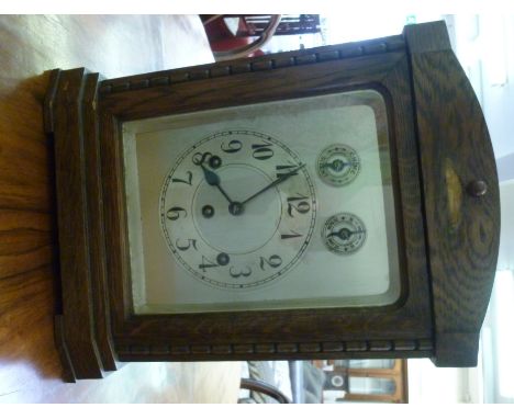 An early 20thC cased mantel clock with an arched top, on block feet; the gong strike movement faced by a silvered Arabic dial