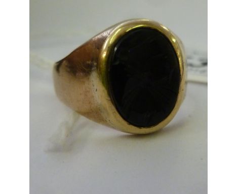 A gold coloured metal signet ring, the oval black tablet engraved with a classical profile portrait        11