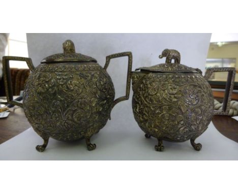 An Indian embossed, cast and chased silver coloured metal sugar basin and cover with a matching lidded jug           11