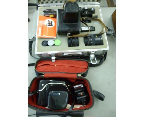 A Zenith 35mm camera, in an alloy carrying case with accessories; and a Praktica MTL3 35mm camera, in a carrying case       S