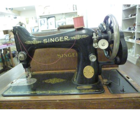 A Singer manual sewing machine, under a laminated oak dome       BSR