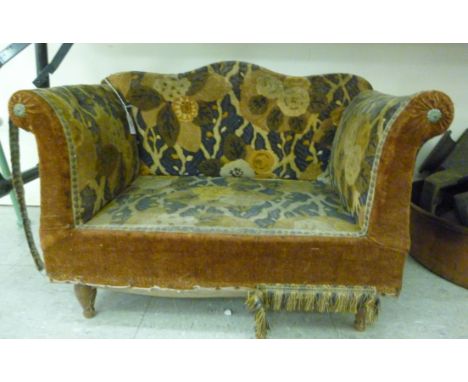 A 1920s doll's settee, having an arched back and level, scrolled arms, on turned feet, upholstered in copper coloured, blue a