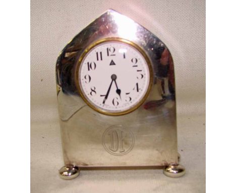 A small silver cased mantel clock, the arched case enclosing a white dial with Arabic numerals,  height 10cm