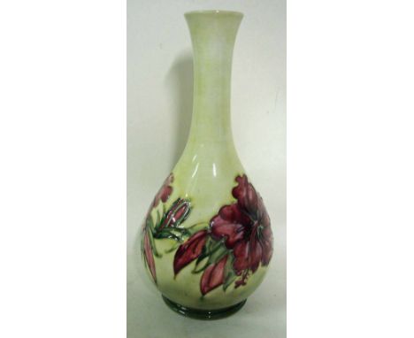 A William Moorcroft pottery bottle vase, tubeline decorated with a band of hibiscus blooms against a yellow/green ground, imp