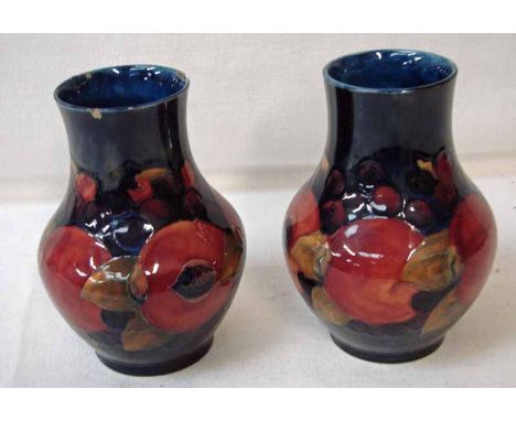 A pair of William Moorcroft Pomegranate pattern vases on a blue ground, with blue painted signature and impressed factory mar