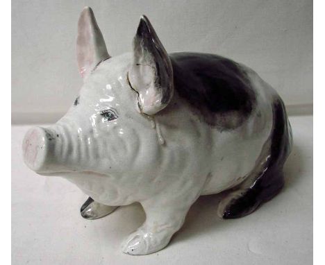 A Wemyss black and white pig, circa 1900, crouching on his haunches, incised Wemyss ware R H & S on base, (both ears are dama