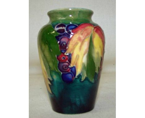 A William Moorcroft leaf and berry vase, on a blue ground, incised Moorcroft and Made in England stamp to base, 10cm high