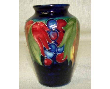 A William Moorcroft leaf and berry vase on a green ground, Moorcroft mark and Made in England incised mark to base, 10cm high