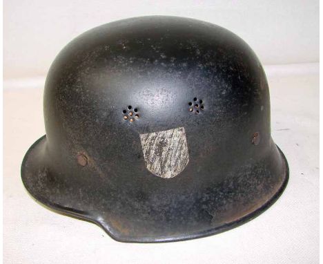 A German WWII police helmet, mod 1934 with leather interior and leather chin strap