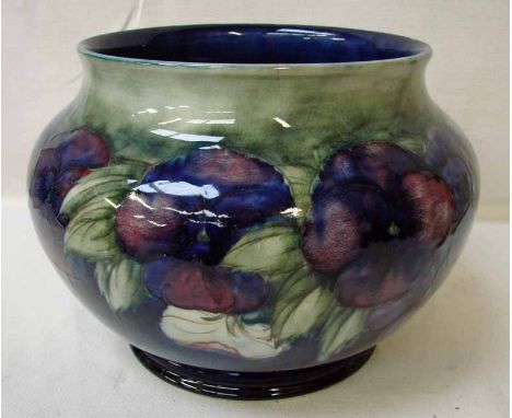 A large William Moorcroft jardiniere, tubeline decorated in the Pansy design on blue/green ground, impressed mark and facsimi