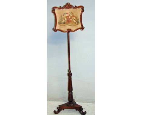An early Victorian mahogany pole screen with carved rectangular shaped frame enclosing tapestry of young boy with a hawk, the