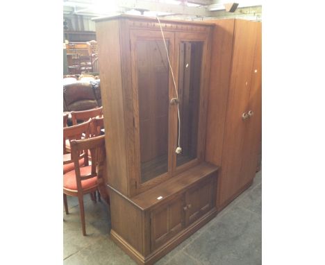 AN ERCOL GLAZED CABINET BOOKCASE. W96CM D50CM H182CM