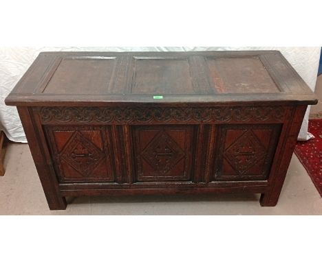 An 18th century oak carved panel front coffer chest