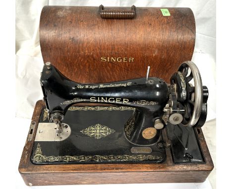 A vintage Singer sewing machine, with original oak cover.
