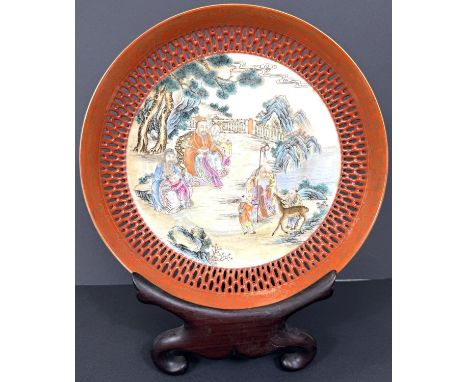 A Chinese plate/shallow bowl with pierced orange border, the centre decorated with figures and children, trees and bridge in 