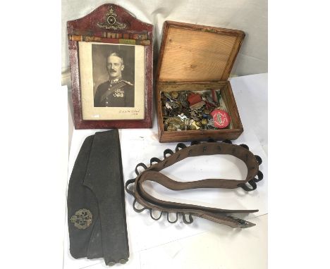 A selection of militaria including badges, buttons, RAF cap, leather belt etc