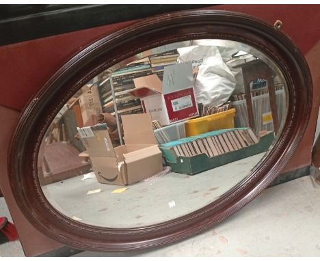 An ornate brass Victorian fender; an oval mahogany wall mirror.