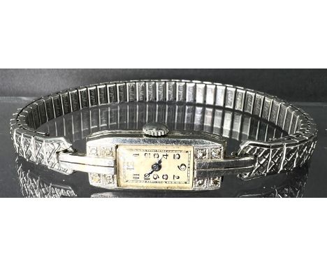 A 1930's/40's vintage lady's cocktail watch with elongated white metal face set with 4 small clear stones, possibly white sap