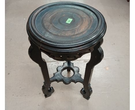 An oriental ebonised plant stand on triple feet with undershelf.