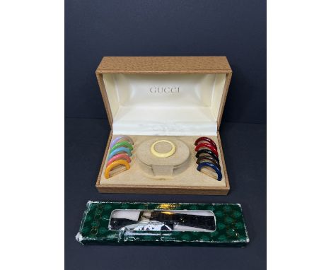 A Gucci boxed set of changeable bezels and a Gucci watch strap.