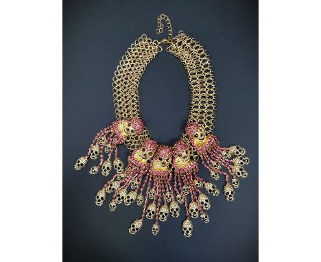 A Butler and Wilson style gilt skull necklace with pink coloured stones