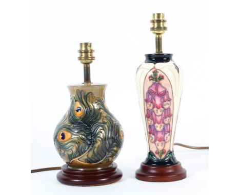 Two modern Moorcroft lamp bases, the first of squat baluster form with peacock pattern, the second slender oviform with purpl