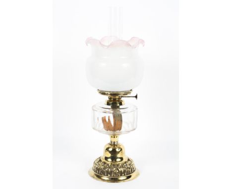 An Edwardian brass mounted oil lamp, the burner marked for Wright &amp; Butler, Birmingham, with opaque pink edged frilled la