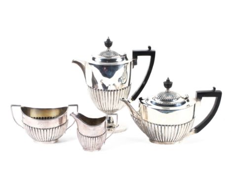 An Edwardian silver four piece tea set, hallmarked Sheffield 1910 by Roberts &amp; Belk, decorated with half fluted design, t