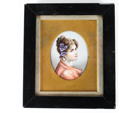 A Continental porcelain oval portrait plaque of a young lady, late 19th century, in glazed frame, 17.5 cm wide inc. frame