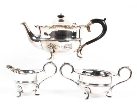 A matched three piece George V silver tea set, comprising: a tea pot,  sugar bowl and milk jug, each with ribbed borders on t