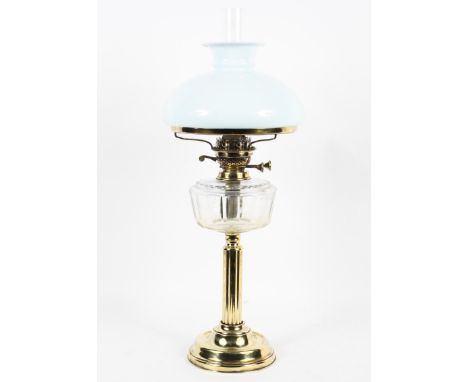 An Edwardian brass-mounted oil lamp and two shades, the lamp on reeded column base, the burner marked 'British made', with op