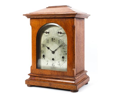 A three-train German oak bracket mantel clock, early 20th century, with silvered dial and black Arabic numerals, with slow/fa