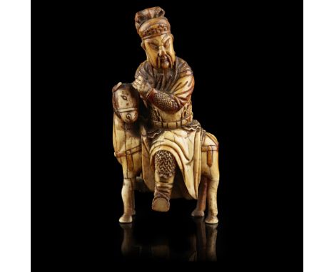 CARVED IVORY EQUESTRIAN FIGURE OF GUANDIMING DYNASTY Guandi shown seated astride a horse with full trappings, wearing a suit 