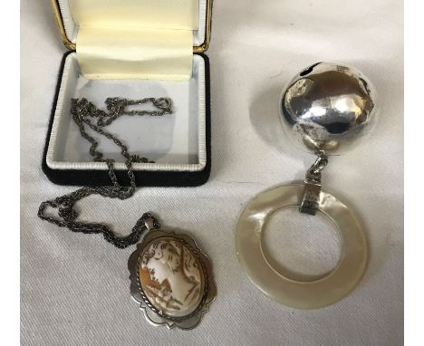 A silver baby's teething rattle ball with mother of pearl ring by T &amp; S Birmingham 1963 together with a hall marked silve