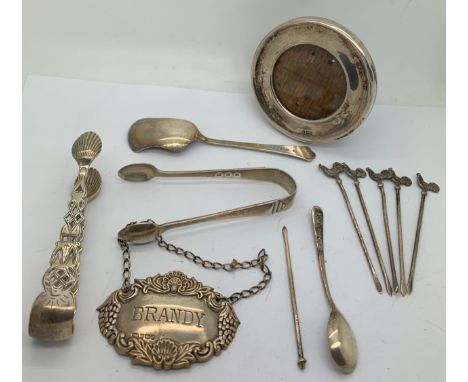 Hallmarked silver to include Brandy label, 5 cockerel sticks, 2 sugar nips, mustard spoon, preserve spoon and round photograp