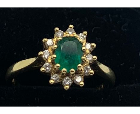 An 18ct gold ring set with single emerald surrounded by diamonds, size L. 3.2gms total weight.Condition ReportGood condition.