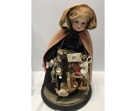 A good example of a Victorian pedlar doll on a circular ebonised base under a glass dome. Doll with a bisque head and brown g